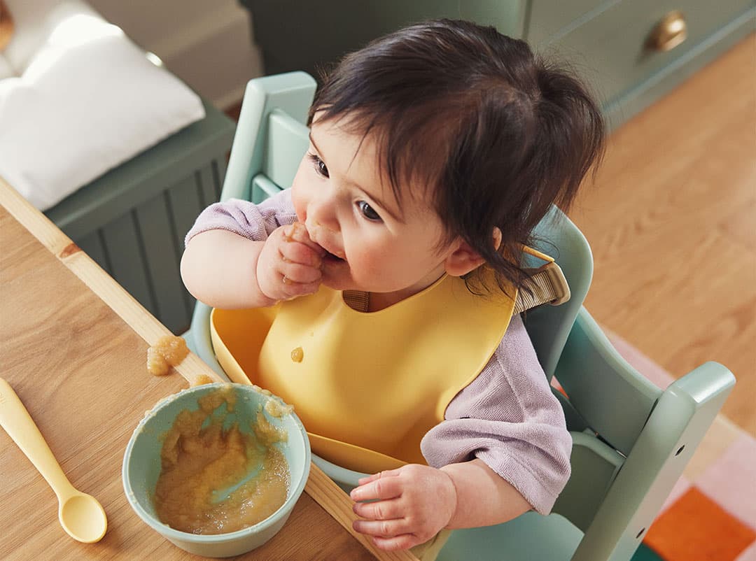 Baby eating from their high chair