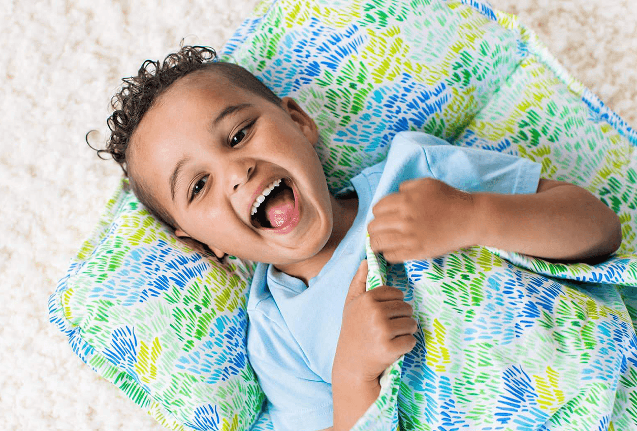 Boy laying in the Nap Mat by Lovevery